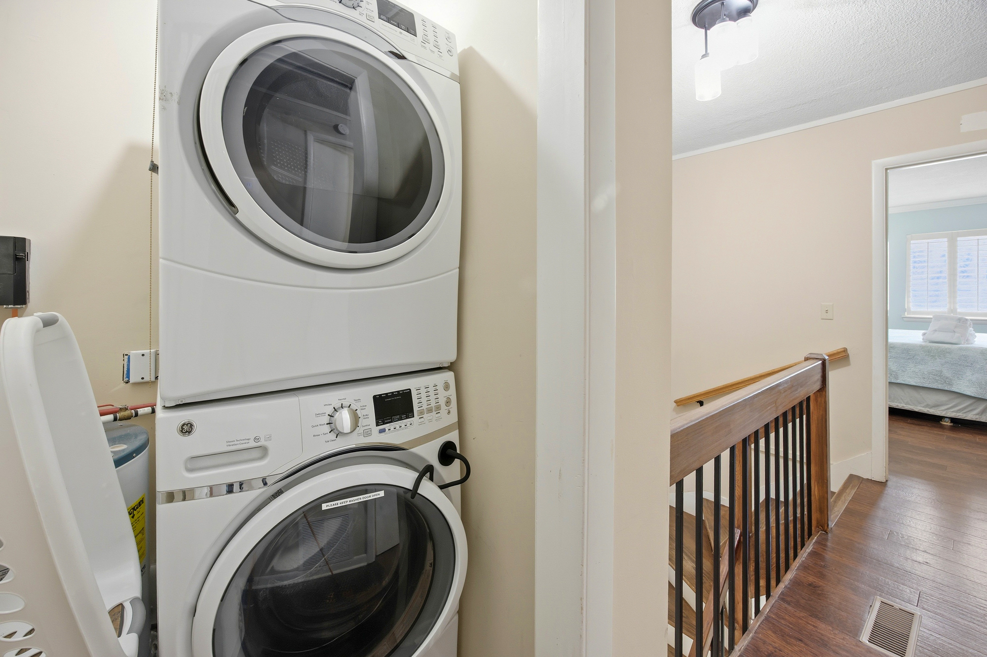 Modern laundry appliances stand ready for your convenience, tucked neatly beside a wood-accented landing. Bright interiors and clean lines ensure chores feel like a breeze during your stay.