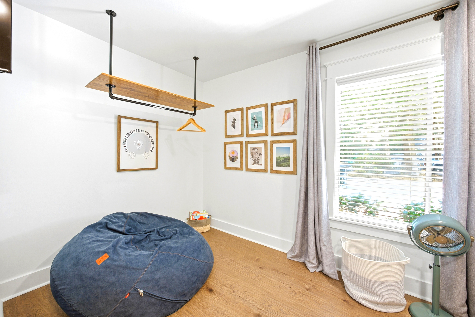 Denim textures and rich wood grains create a cozy corner for quiet afternoons. Gentle daylight filters through the blinds, illuminating the gallery wall and industrial accents to offer a stylish, serene space for your morning coffee.