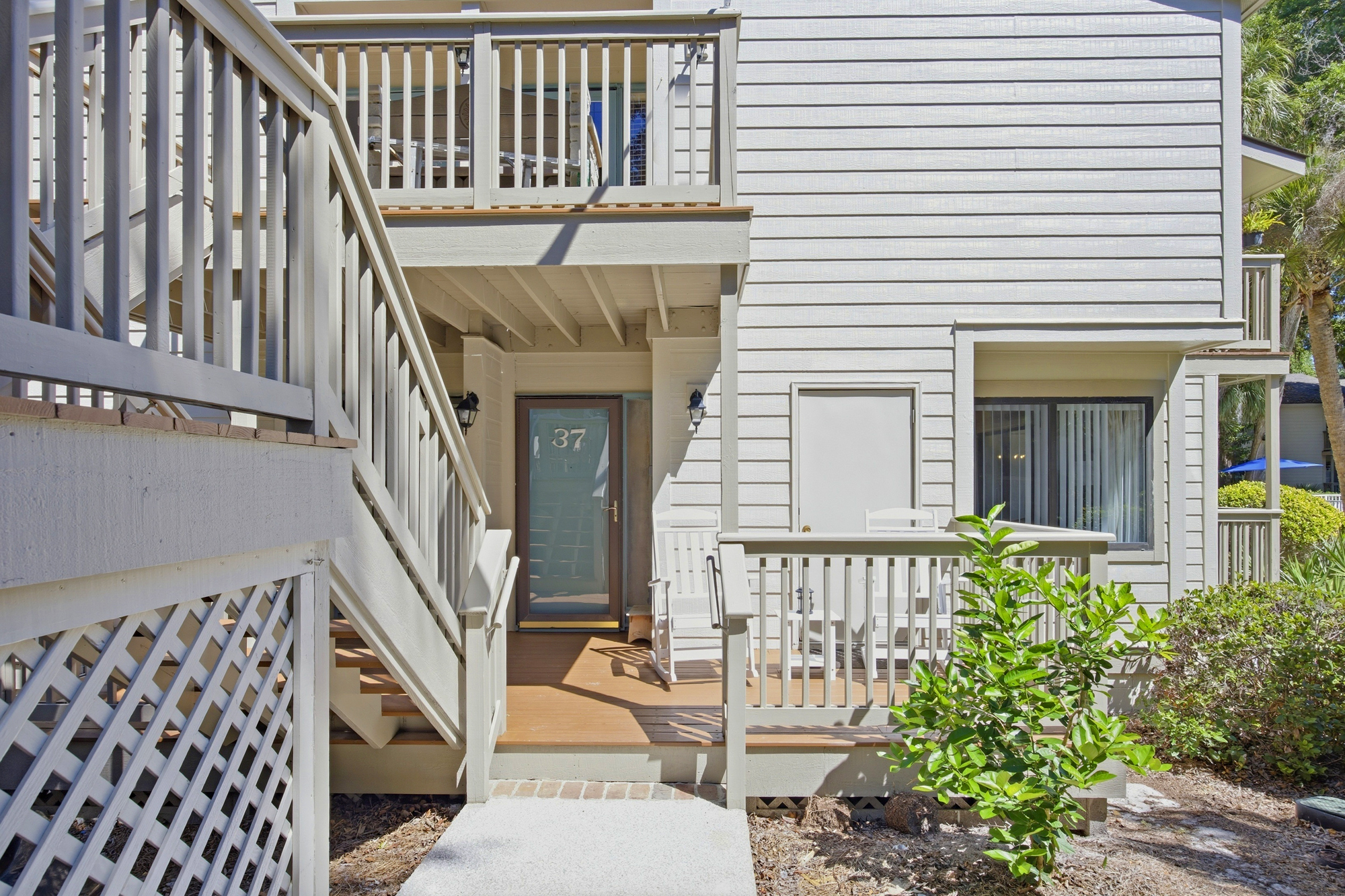 Weathered wood and soft, neutral siding create a coastal charm that begins the moment you approach the porch. Bright morning rays highlight the private rocking chairs, providing a quiet corner to sip coffee and breathe in the fresh air.