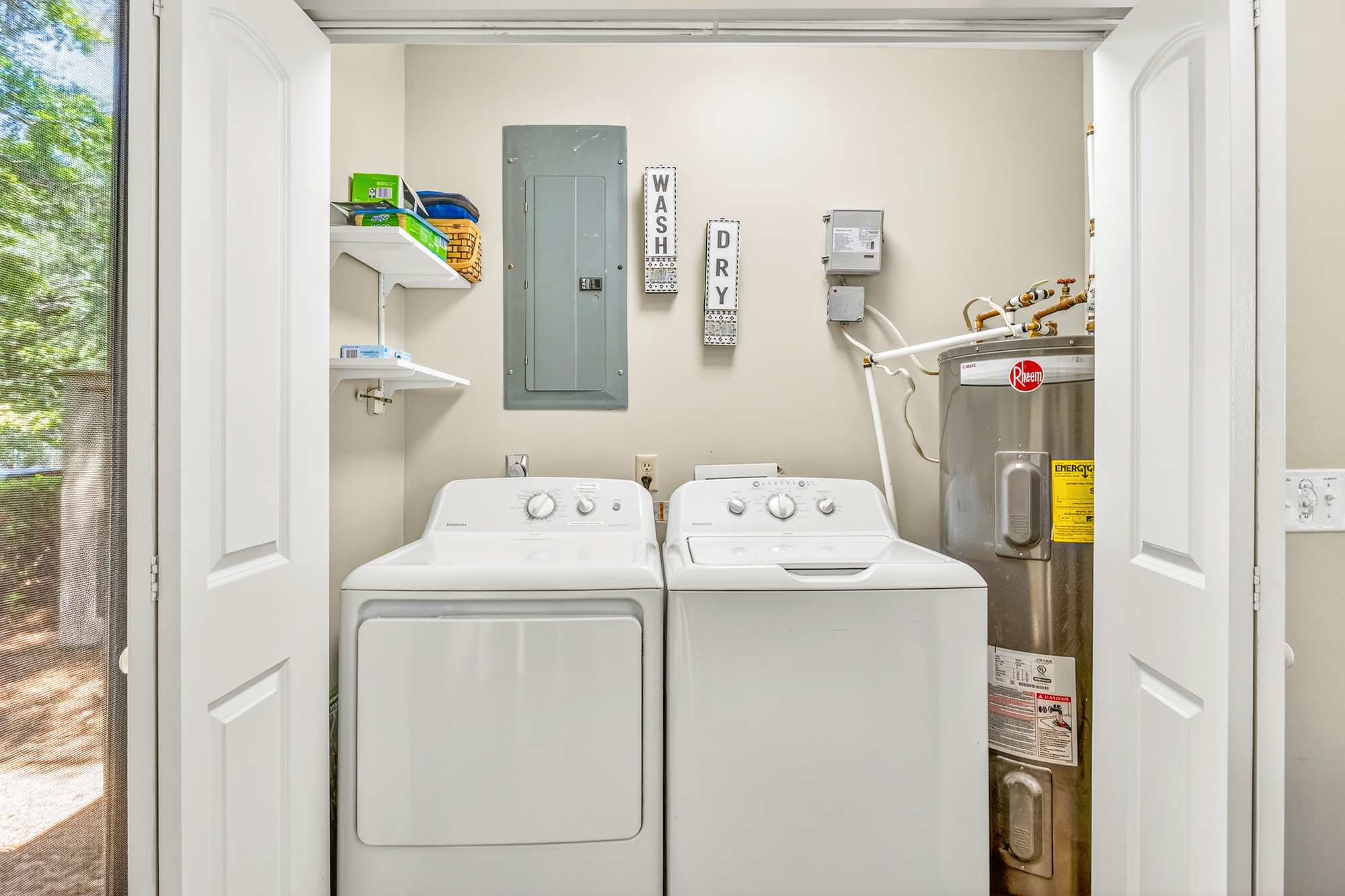 Crisp white appliances sit tucked away in this tidy utility nook, offering everything needed for a fresh start to your day. Clean lines and organized shelving make laundry chores feel effortless and bright.