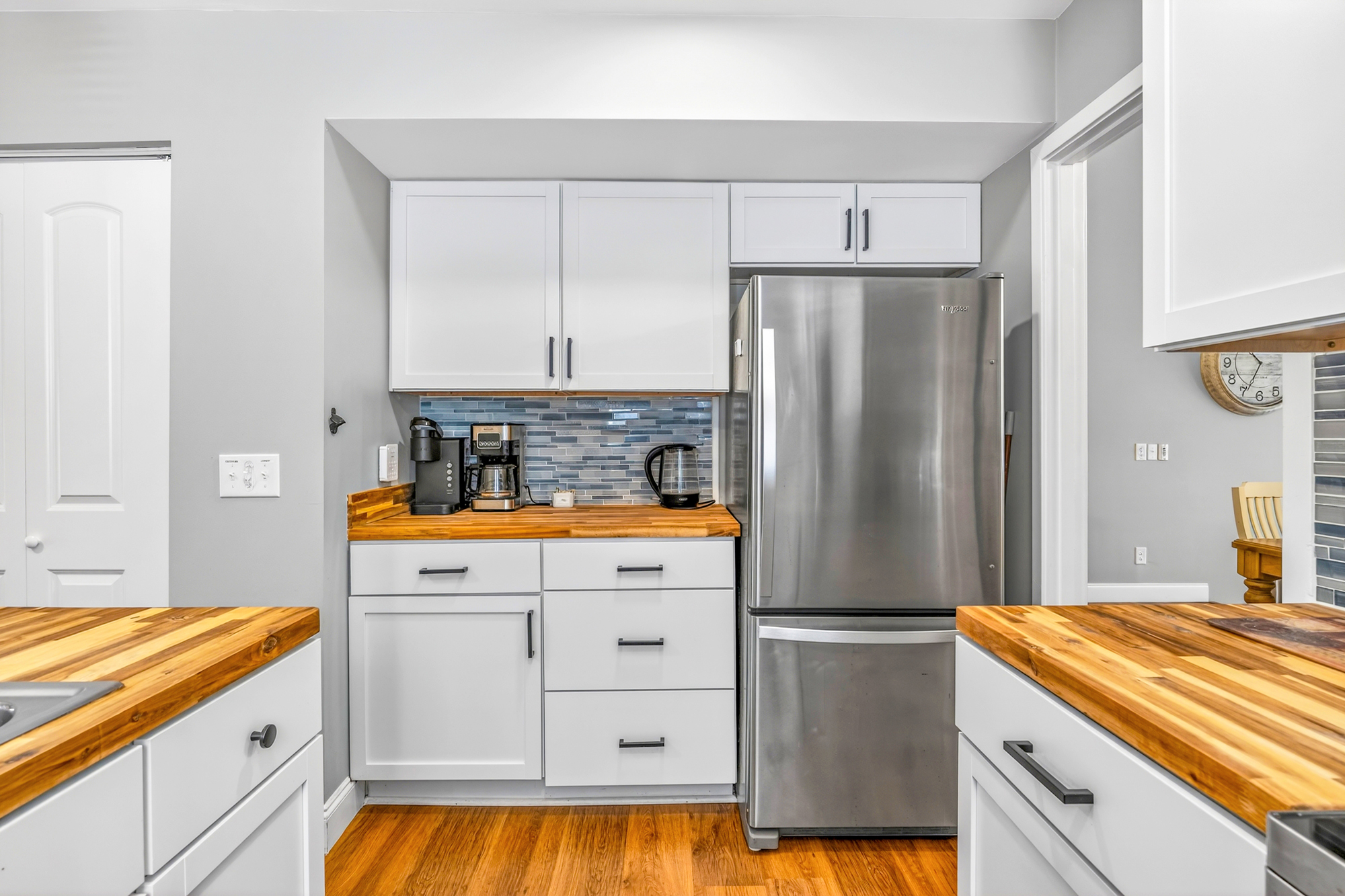 Gleaming stainless steel meets the rich grain of wood counters in this efficient coffee nook. Cool blue tiles add a splash of color to the bright, airy kitchen, making it a cheerful spot to brew your first cup of the day.