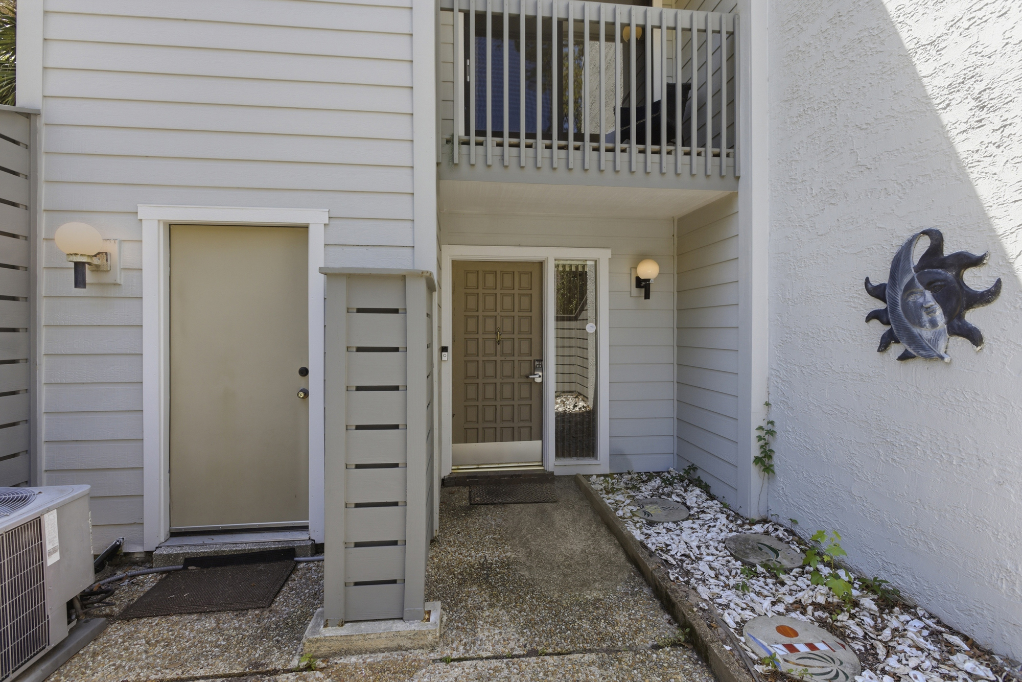 White seashells and celestial wall art create a charming first impression as you approach the private entryway. Soft glow from the globe lights illuminates the path to your secluded getaway.