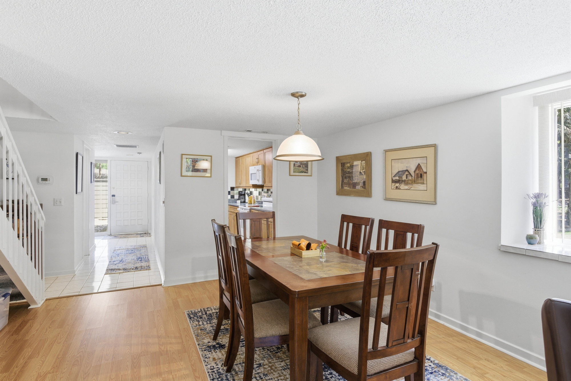 Rich timber tones and soft afternoon light create an intimate setting for shared meals. This airy dining corner pairs smooth wood textures with bright, clean walls to offer a calm space for morning coffee or slow evening conversations.