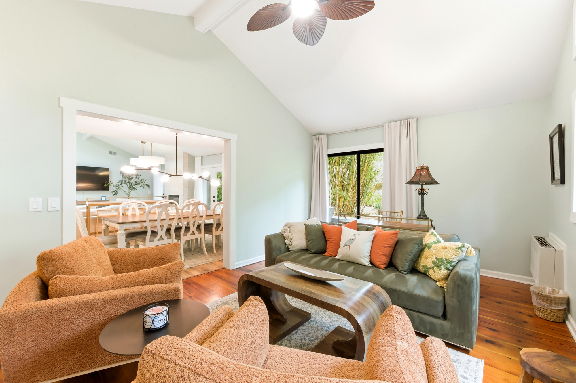 Earthy tones and plush textures create a cozy lounge area, where sunlit garden views peek through the glass. Polished wood floors and a vaulted ceiling offer a sense of airy calm, perfect for slow mornings or quiet conversation.